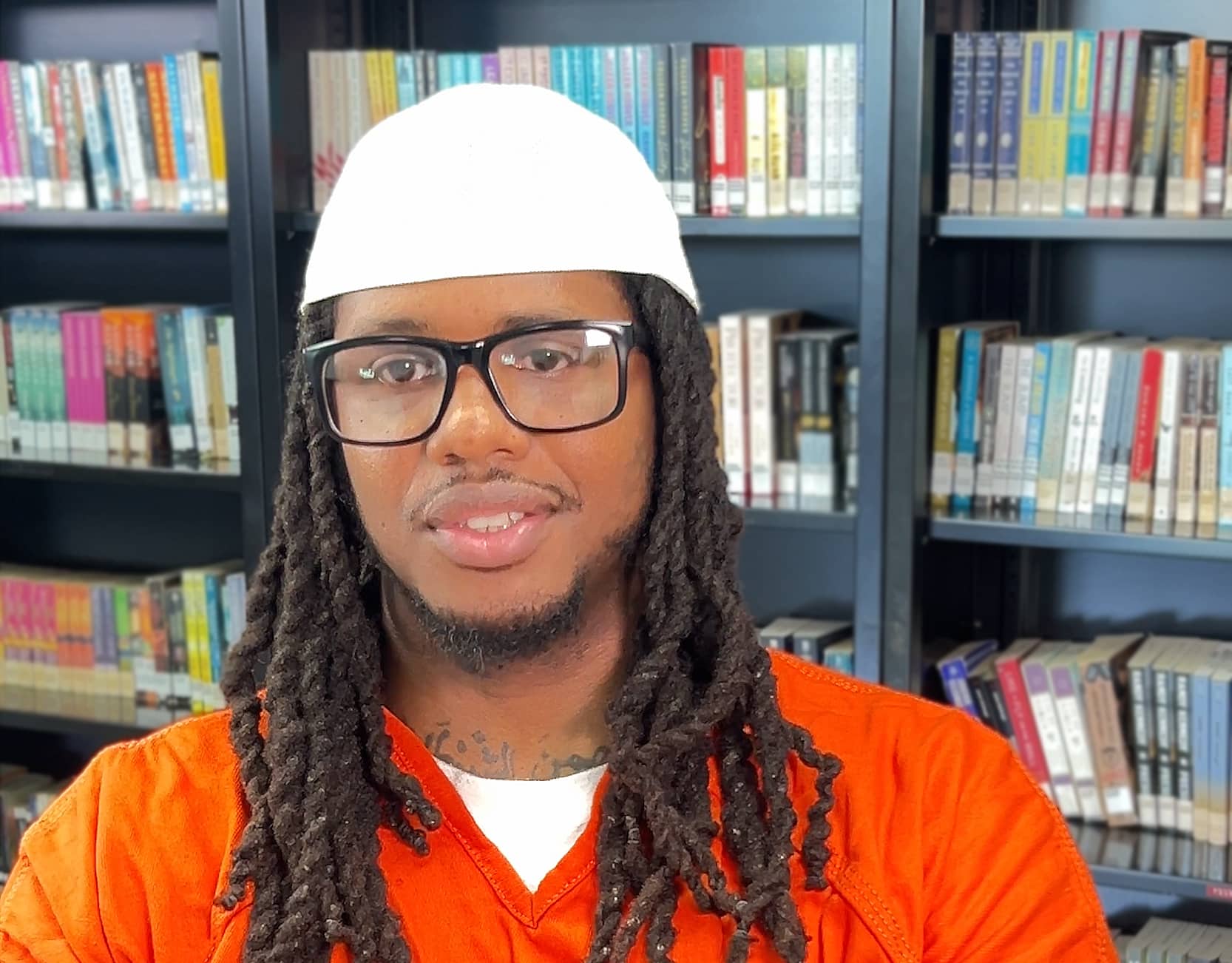 Portrait photo of Ronnell seated in front of a book case with books.