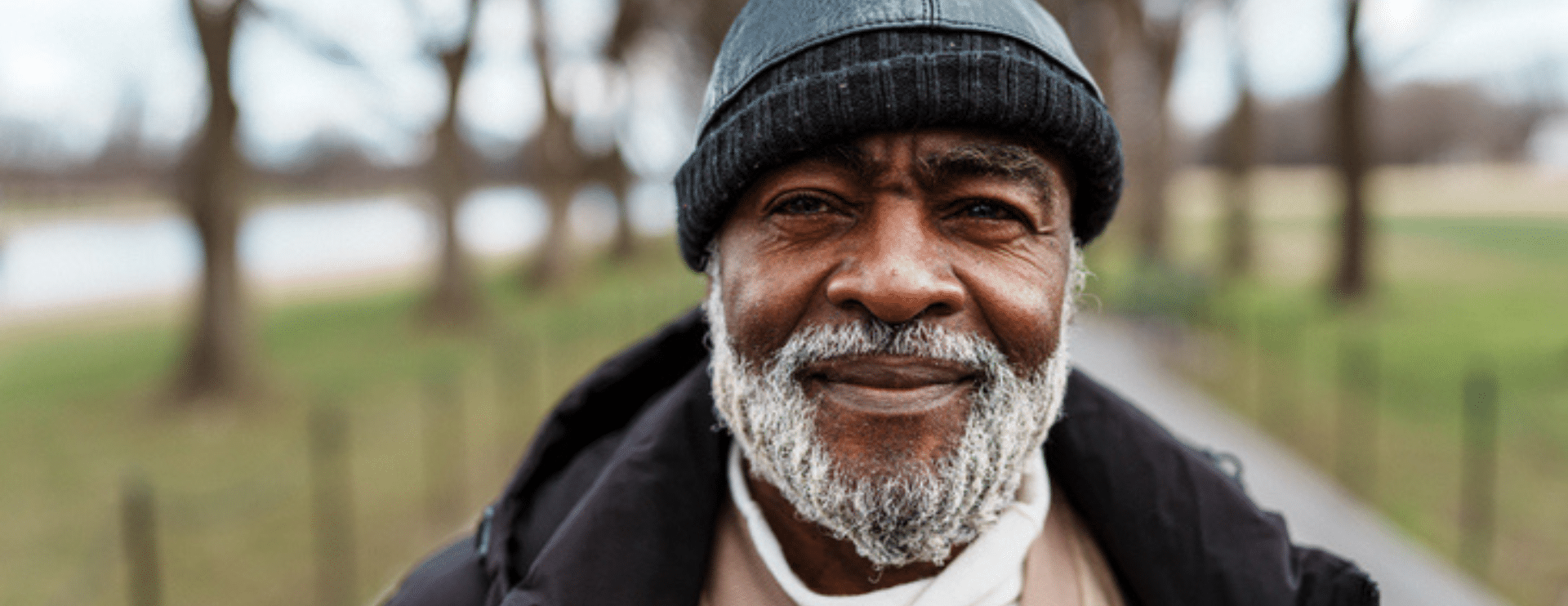 Older African-American man with beard wearing winter hat.